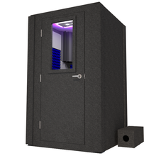 Load image into Gallery viewer, Front view of WhisperRoom's Voice Over Basic Package - a 4' x 4' single-wall vocal booth, complete with acoustic treatment, a functional desk, studio lighting, and various additional features. The left-hinged door is closed, with the interior elegantly adorned in vibrant blue StudioFoam.
