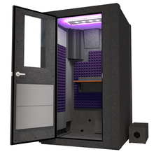 Load image into Gallery viewer, Angled view of WhisperRoom's Voice Over Basic Package - a 4' x 4' single-wall vocal booth, meticulously designed with acoustic treatment, a functional desk, studio lighting, and a comprehensive range of premium features. The left-hinged door is open, revealing the interior enhanced by elegant purple StudioFoam, creating an ideal recording atmosphere.