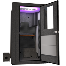 Load image into Gallery viewer, Angled view of the WhisperRoom's Voice Over Basic Package - a 4' x 4' single-wall vocal booth, featuring acoustic treatment, a functional desk, studio lighting, and a range of premium features. The right-hinged door is open, revealing the interior enhanced by elegant gray StudioFoam, providing an ideal recording setting.