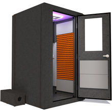 Load image into Gallery viewer, Side view of the WhisperRoom's Voice Over Basic Package - a 4' x 4' single-wall vocal booth, thoughtfully furnished with acoustic treatment, a functional desk, studio lighting, and a comprehensive range of premium features. The right-hinged door is open, revealing the interior accented with vibrant orange StudioFoam, creating an inviting and professional recording space.