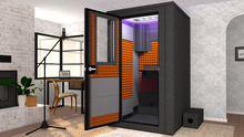 Load image into Gallery viewer, WhisperRoom's Voice Over Deluxe Package: A 4'x4' Double-Wall Vocal Booth equipped with Bass Traps, a Folding Office Desk, Orange Auralex StudioFoam, an Exterior Fan Silencer, Multi-Colored LED Studio Light, and an Acoustic Package, perfectly integrated into a living room home recording studio setup next to a fireplace with a chair at a desk, a laptop, and a complete various other equipment for voiceover.