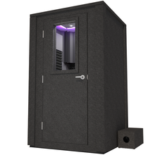 Load image into Gallery viewer, Angled view of WhisperRoom's Voice Over Deluxe Package - a 4' x 4' double-wall vocal booth, meticulously designed with acoustic treatment, a functional desk, studio lighting, and a comprehensive range of premium features. The left-hinged door is closed, and the interior is enhanced by sophisticated gray StudioFoam, creating an ideal recording environment.