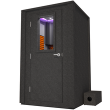 Load image into Gallery viewer, Frontal view of WhisperRoom's Voice Over Deluxe Package - a 4' x 4' double-wall vocal booth, meticulously designed with acoustic treatment, a functional desk, studio lighting, and a comprehensive range of premium features. The left-hinged door is closed, and the interior is enhanced by vibrant orange StudioFoam, creating an ideal recording environment.