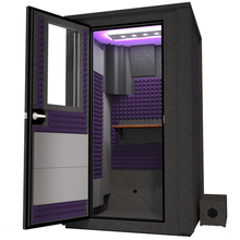 Load image into Gallery viewer, Angled view of the WhisperRoom's Voice Over Deluxe Package - a 4' x 4' double-wall vocal booth, thoughtfully equipped with acoustic treatment, a functional desk, studio lighting, and an array of premium features. The left-hinged door is open, revealing the interior enhanced by elegant purple StudioFoam, creating an ideal recording atmosphere.