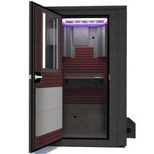 Load image into Gallery viewer, Frontal view of WhisperRoom's Voice Over Deluxe Package - a 4' x 4' double-wall vocal booth, meticulously designed with acoustic treatment, a functional desk, studio lighting, and a comprehensive range of premium features. The left-hinged door is open, revealing the interior enhanced by sophisticated burgundy StudioFoam, creating an ideal recording atmosphere.
