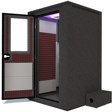 Load image into Gallery viewer, Side view of the WhisperRoom's Voice Over Deluxe Package - a 4' x 4' double-wall vocal booth, thoughtfully equipped with acoustic treatment, a functional desk, studio lighting, and an array of premium features. The left-hinged door is open, revealing the interior enhanced by sophisticated burgundy StudioFoam, creating an ideal recording atmosphere.