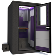 Load image into Gallery viewer, Angled view of WhisperRoom's Voice Over Deluxe Package - a 4' x 4' double-wall vocal booth, meticulously designed with acoustic treatment, a functional desk, studio lighting, and a comprehensive range of premium features. The right-hinged door is open, revealing the interior enhanced by elegant purple StudioFoam, creating an ideal recording atmosphere.