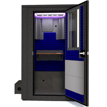 Load image into Gallery viewer, Frontal view of WhisperRoom's Voice Over Deluxe Package - a 4' x 4' double-wall vocal booth, meticulously designed with acoustic treatment, a functional desk, studio lighting, and a comprehensive range of premium features. The right-hinged door is open, revealing the interior accentuated with vibrant blue StudioFoam, creating an ideal recording environment.