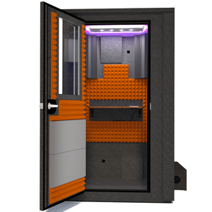 Frontal view of WhisperRoom's Voice Over Deluxe Package - a 4' x 4' double-wall vocal booth, meticulously designed with acoustic treatment, a functional desk, studio lighting, and a comprehensive range of premium features. The left-hinged door is open, revealing the interior enhanced by vibrant orange StudioFoam, creating an ideal recording atmosphere.