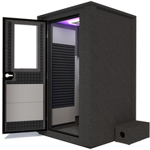 Load image into Gallery viewer, Side view of the WhisperRoom&#39;s Voice Over Deluxe Package - a 4&#39; x 4&#39; double-wall vocal booth, thoughtfully equipped with acoustic treatment, a functional desk, studio lighting, and an array of premium features. The left-hinged door is open, revealing the interior enhanced by sophisticated gray StudioFoam, creating an ideal recording atmosphere.
